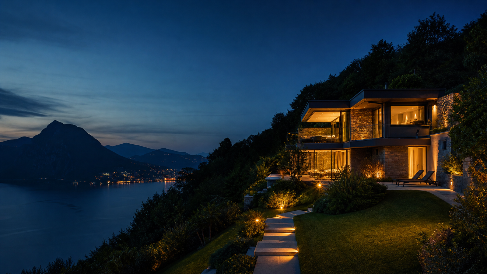 Illuminated villa overlooking Lake Lugano at dusk
